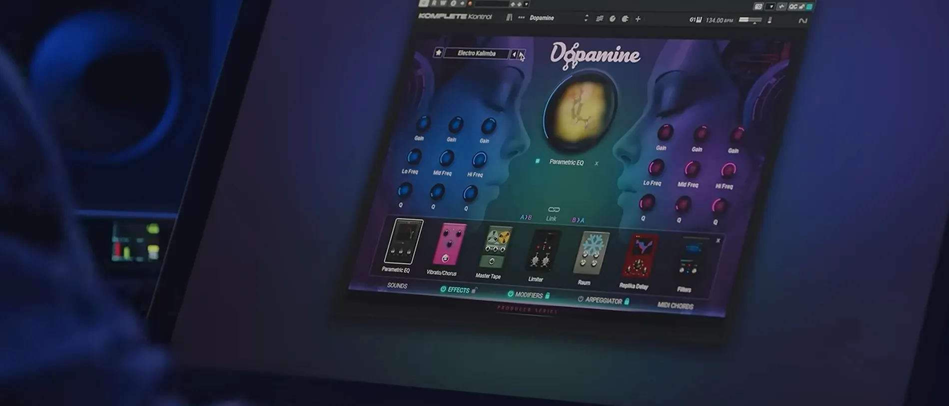The Dopamine interface open on a studio screen in a dark room, its two mirrored faces lit cyan and magenta.